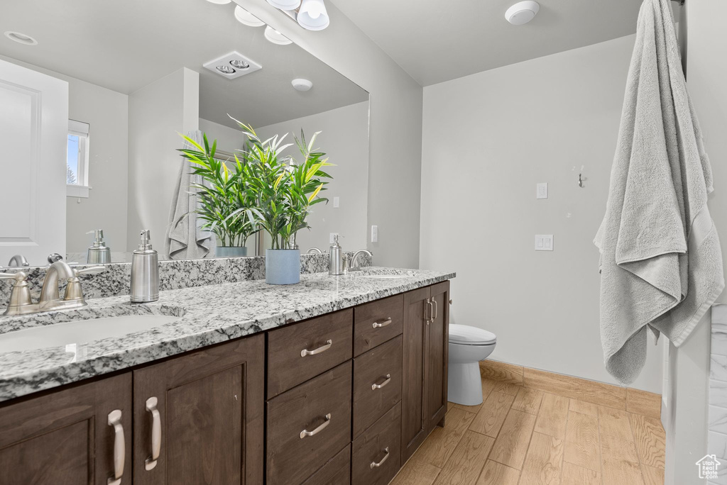Bathroom featuring double vanity and wood finished floors