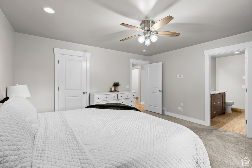Bedroom with light colored carpet, ensuite bathroom, recessed lighting, and ceiling fan