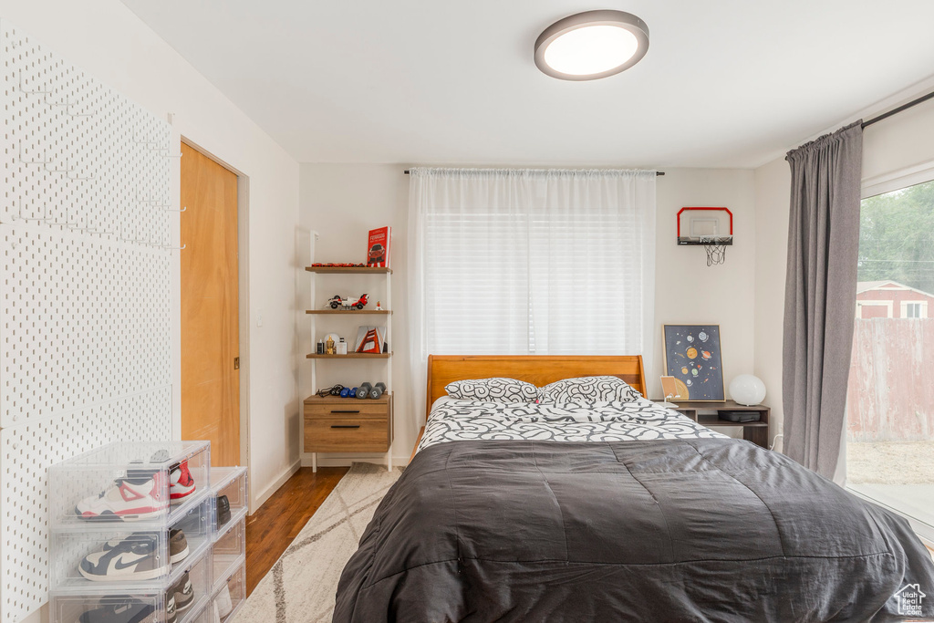 Bedroom with wood finished floors and baseboards
