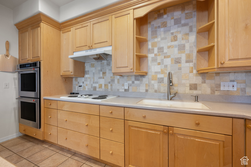 Kitchen featuring open shelves, stainless steel double oven, and light brown cabinetry