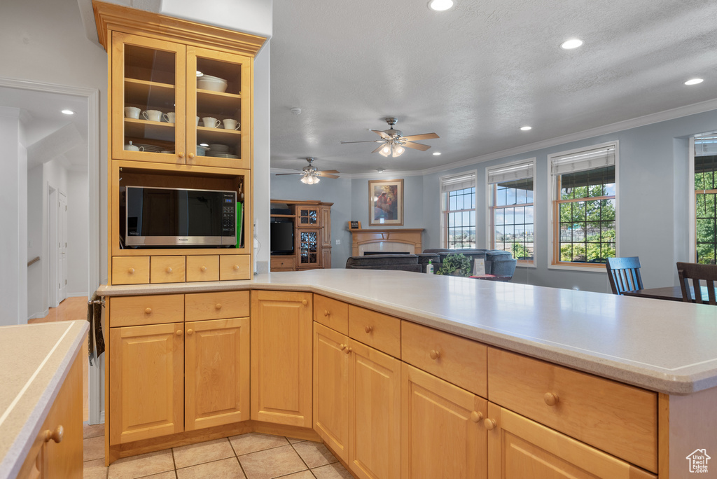 Kitchen featuring black microwave, recessed lighting, light countertops, crown molding, and light brown cabinets