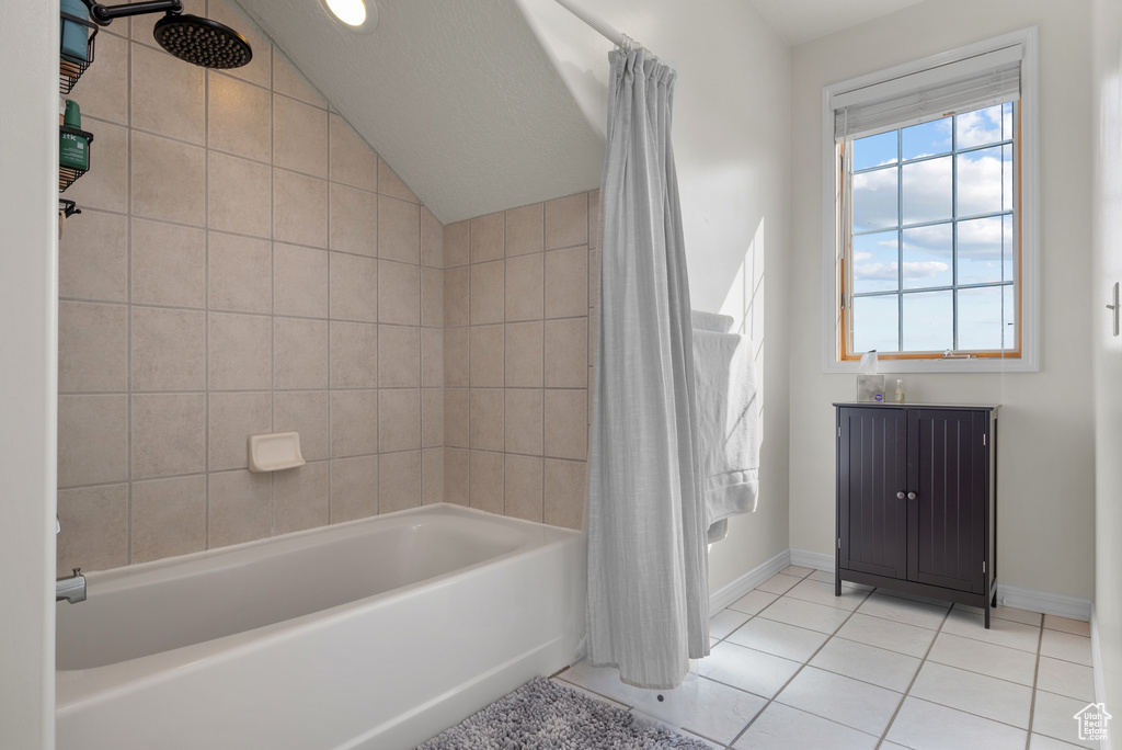 Bathroom featuring tile patterned floors, lofted ceiling, and shower / bath combo
