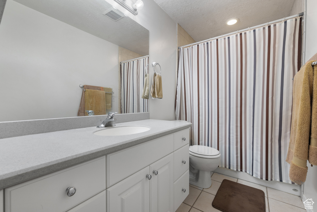 Full bath featuring vanity, tile patterned flooring, a shower with shower curtain, and a textured ceiling