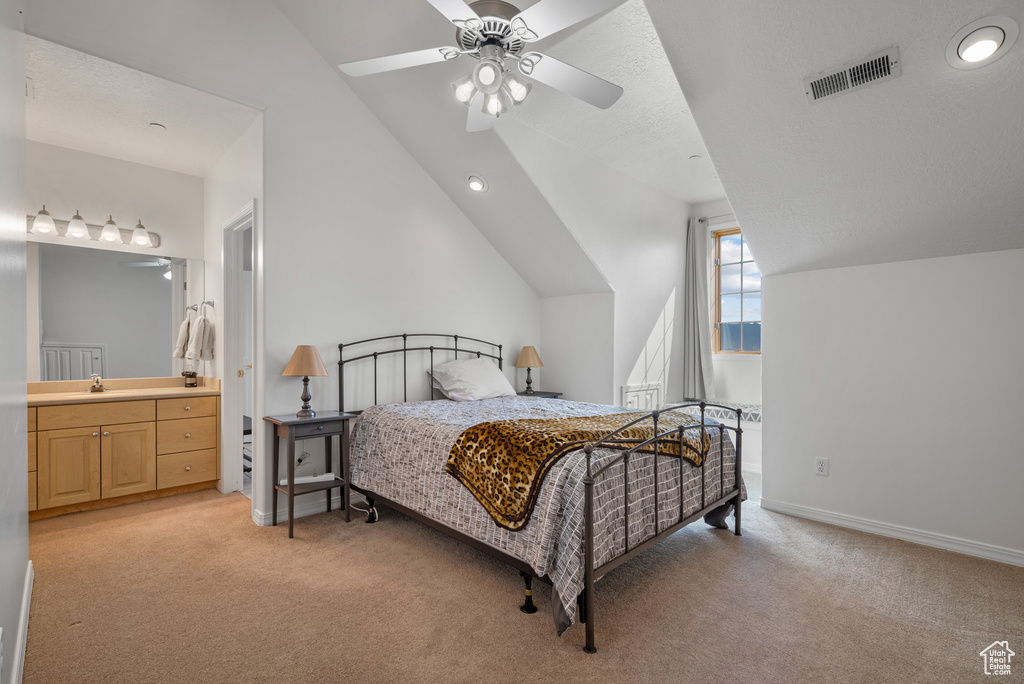 Bedroom with light carpet, vaulted ceiling, ensuite bathroom, ceiling fan, and recessed lighting