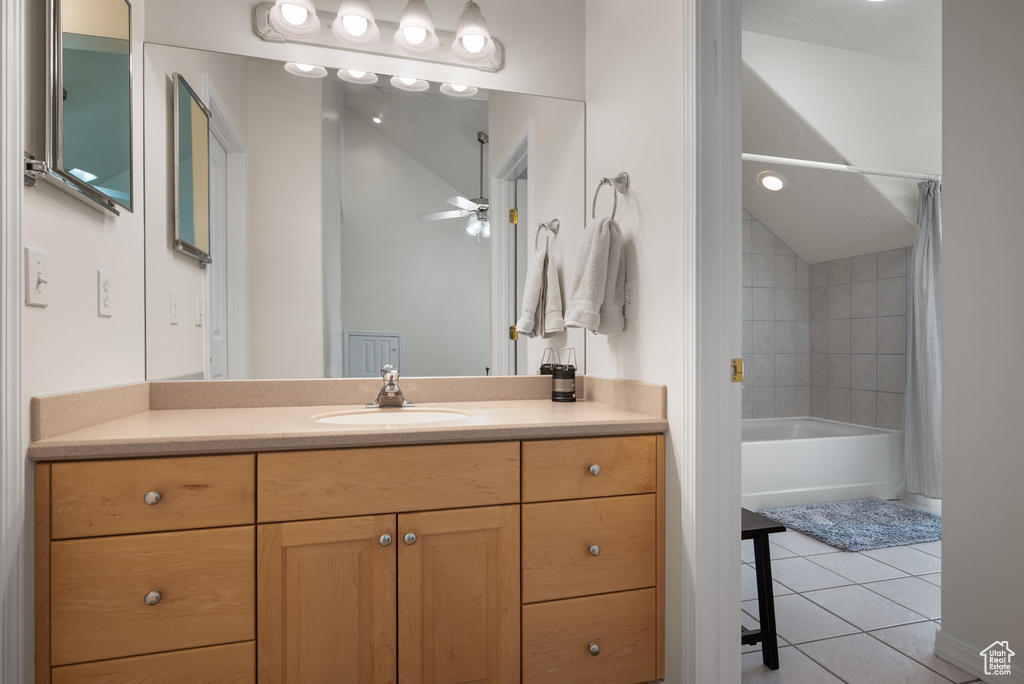 Bathroom with tile patterned floors, vanity, shower / tub combo, ceiling fan, and vaulted ceiling