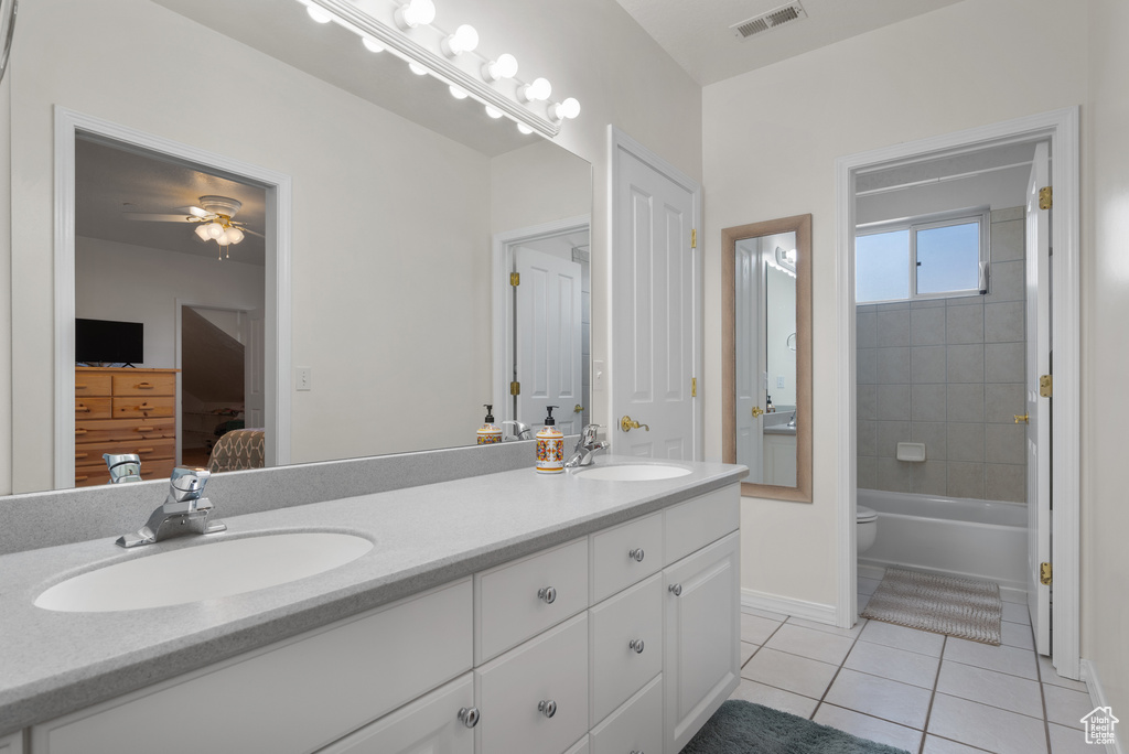 Full bathroom with ensuite bath, tile patterned flooring, double vanity, ceiling fan, and shower / bath combination