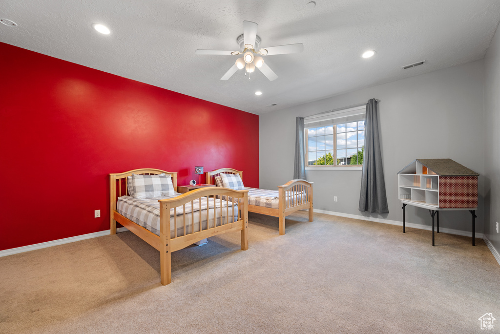 Carpeted bedroom with an accent wall, recessed lighting, and ceiling fan