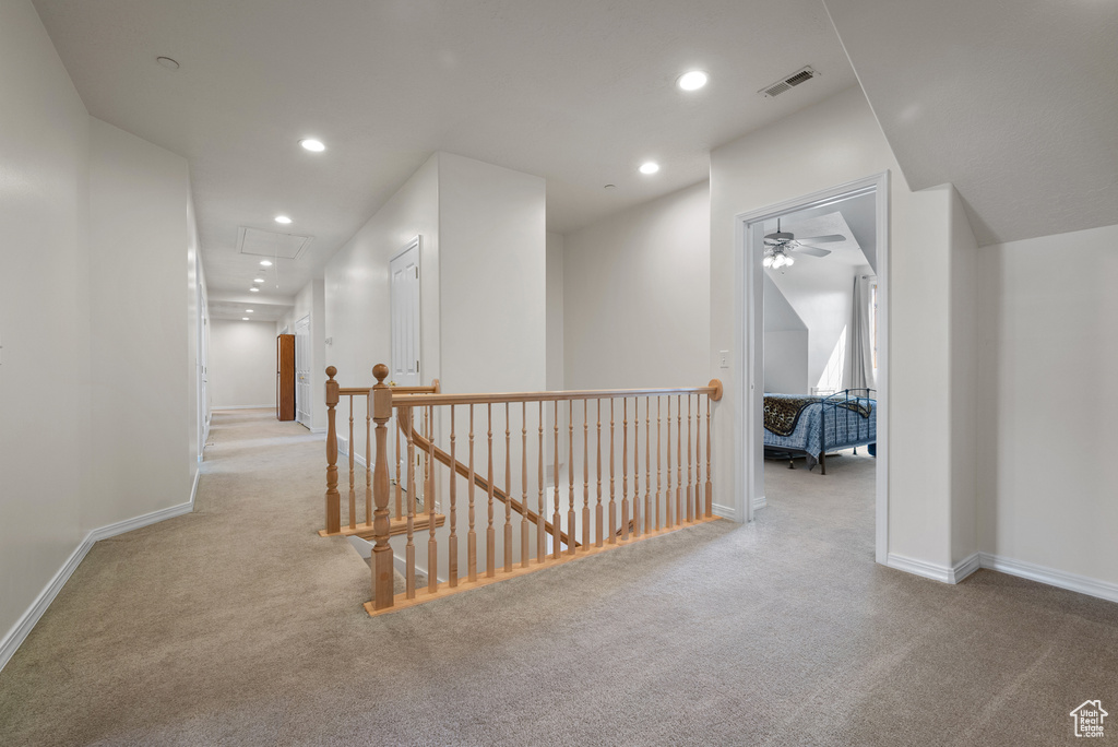 Hall with an upstairs landing, carpet flooring, and recessed lighting
