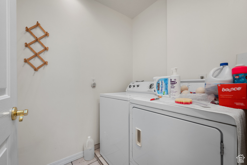 Laundry room featuring independent washer and dryer and light tile patterned floors