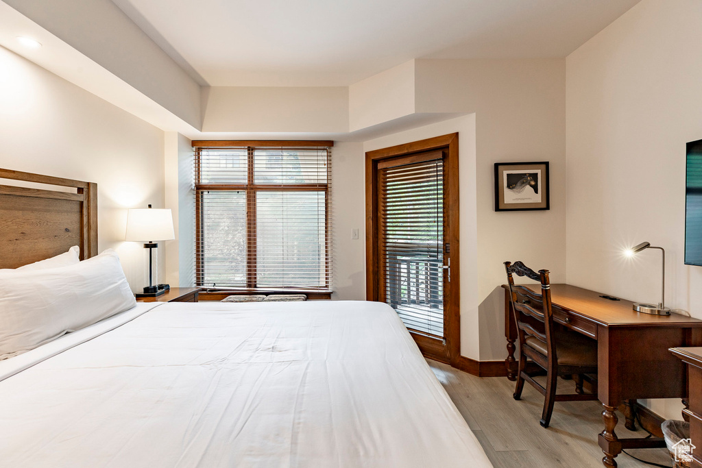 Bedroom with light wood-style flooring, access to outside, and an office area