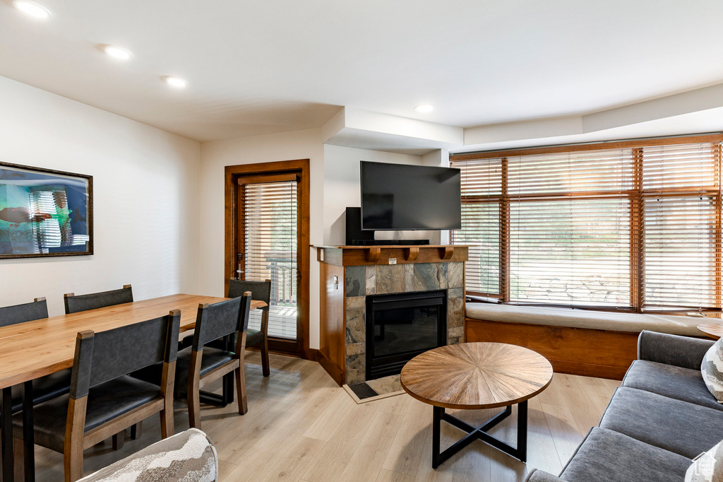 Living room with light wood-style flooring, a tile fireplace, and recessed lighting