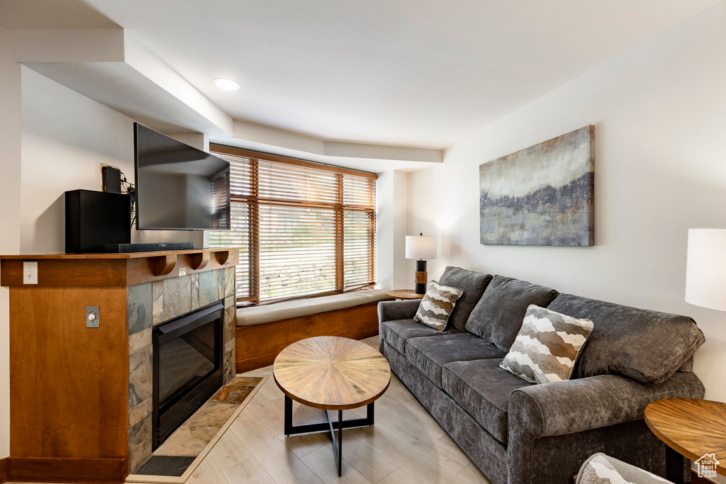 Living area featuring a tile fireplace, light wood-style floors, and recessed lighting