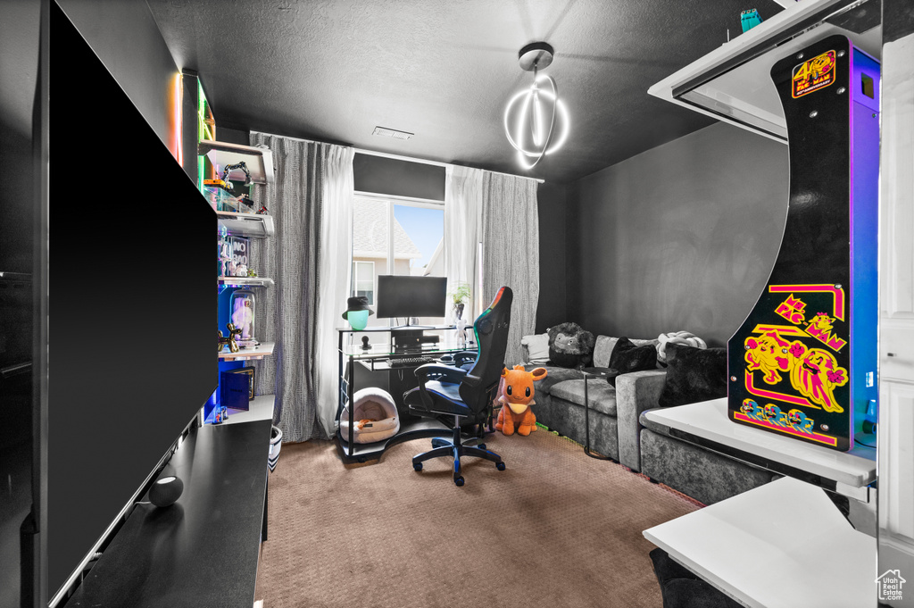 Carpeted home office with a textured ceiling