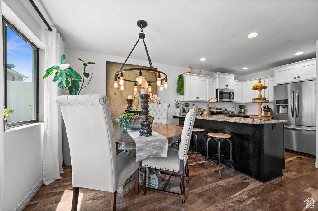 Dining space featuring dark wood-type flooring, a chandelier, and recessed lighting