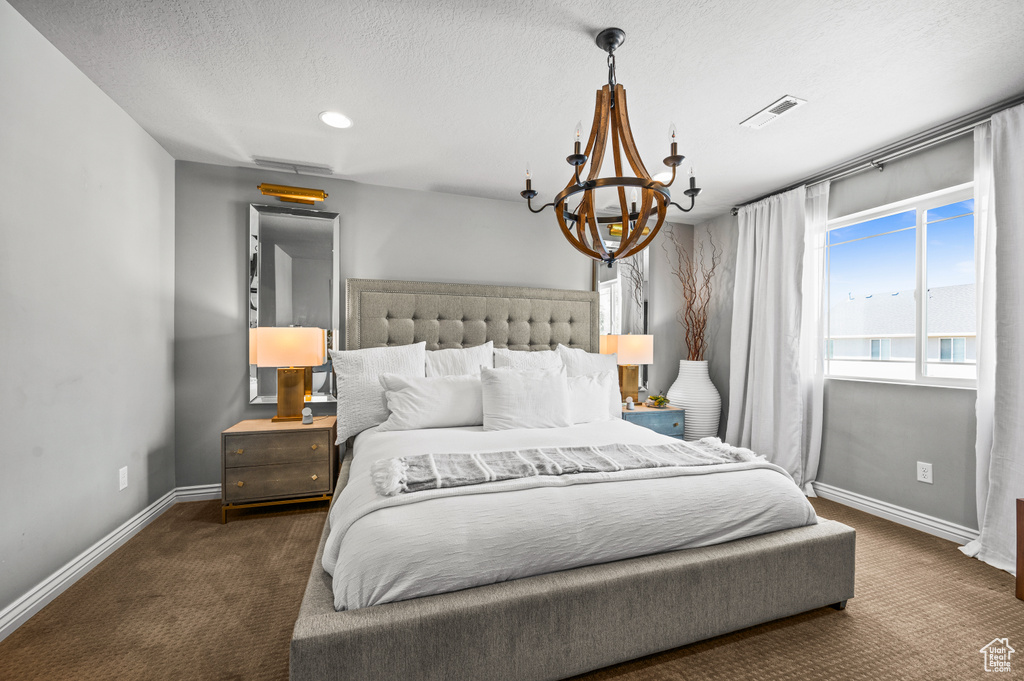 Bedroom featuring carpet floors, a chandelier, a textured ceiling, and recessed lighting