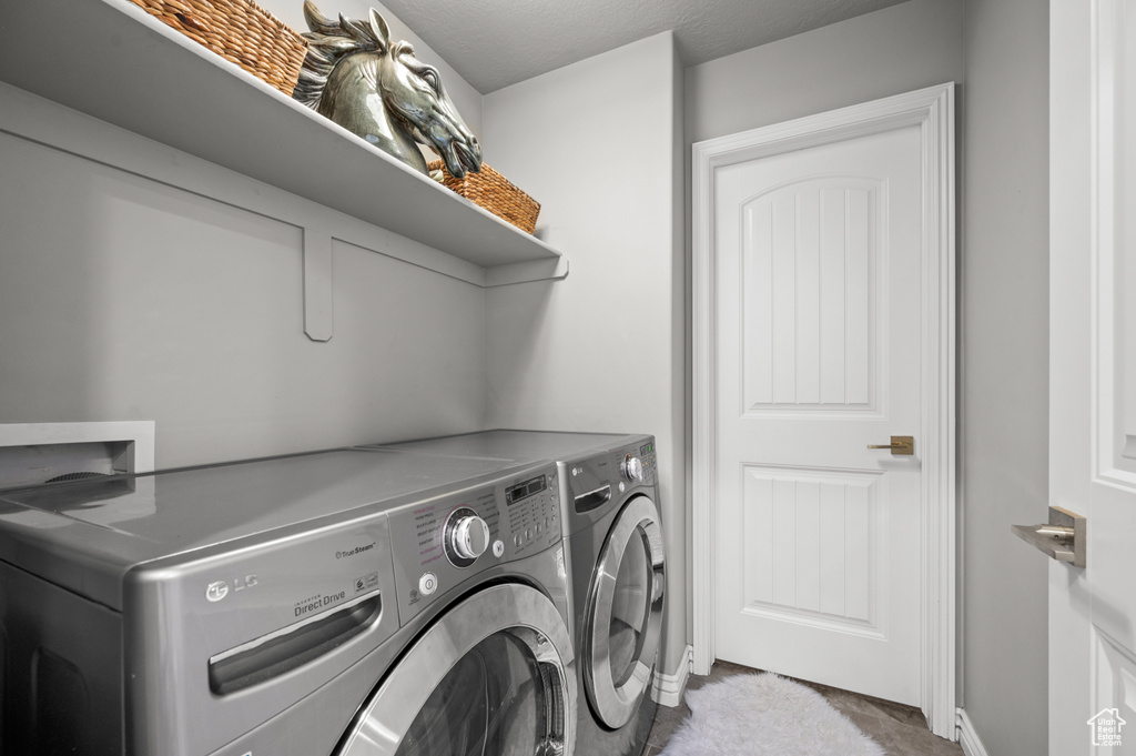Laundry area with independent washer and dryer and baseboards