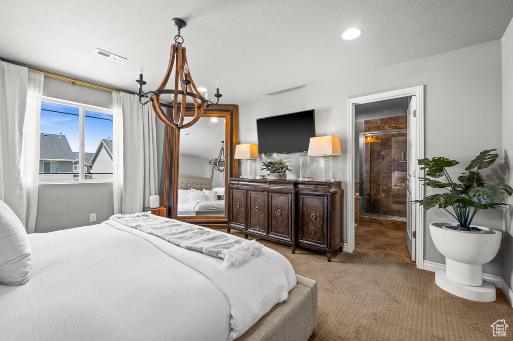 Bedroom with a chandelier, carpet floors, and a textured ceiling