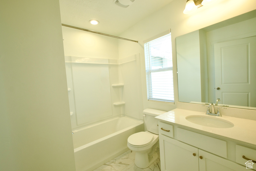 Full bath featuring vanity, marble look tiles, shower / washtub combination, and recessed lighting