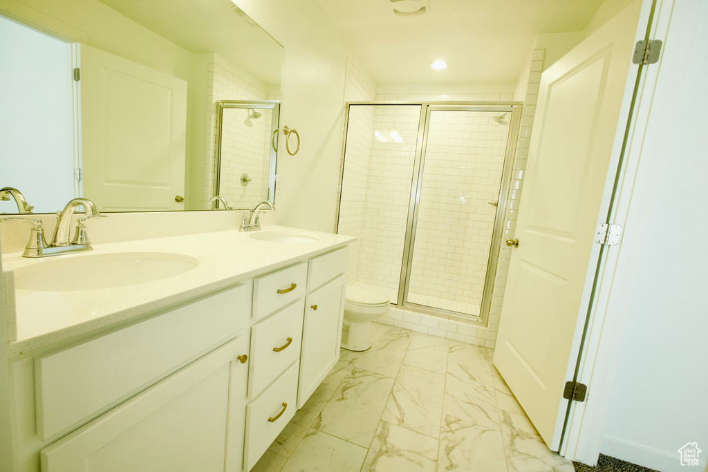 Full bathroom with marble look tile flooring, recessed lighting, a stall shower, and double vanity