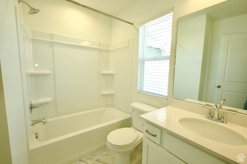Bathroom featuring vanity, tub / shower combination, and marble finish flooring