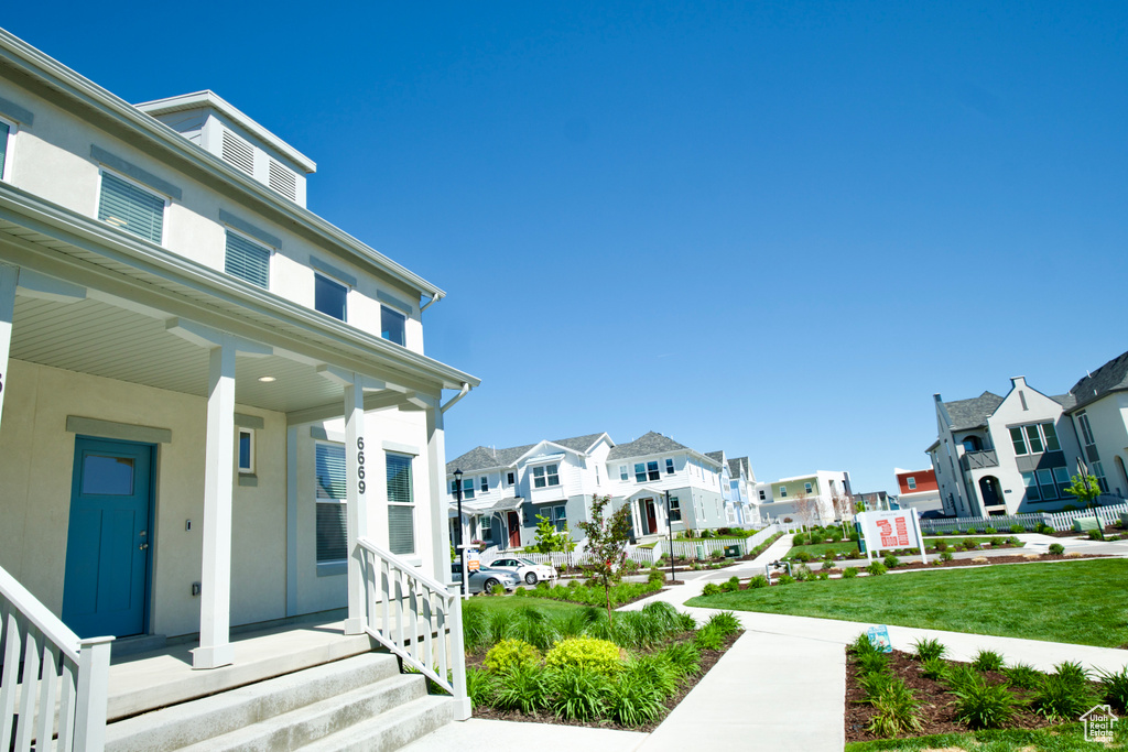 Exterior space featuring a residential view, a porch, and stucco siding