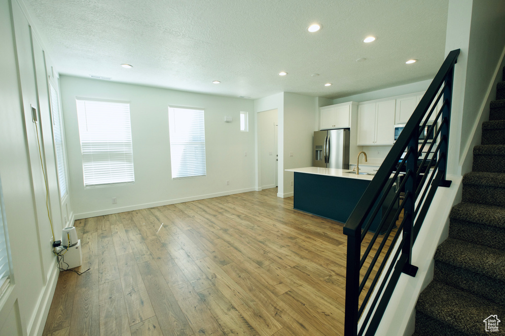 Foyer entrance with recessed lighting, stairway, and light wood-style flooring