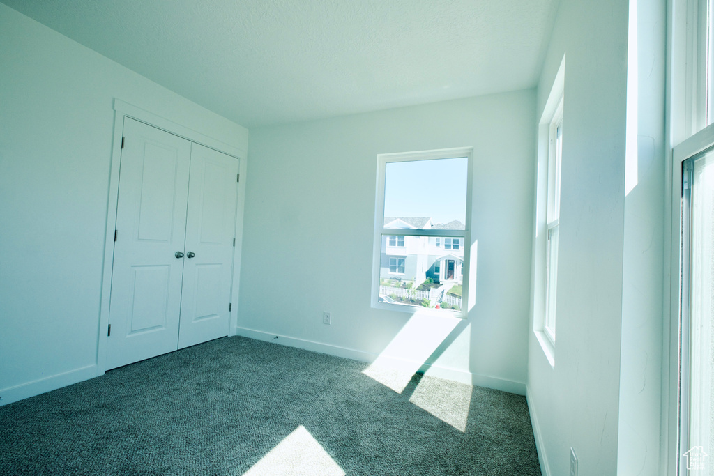 Unfurnished bedroom featuring carpet and a closet