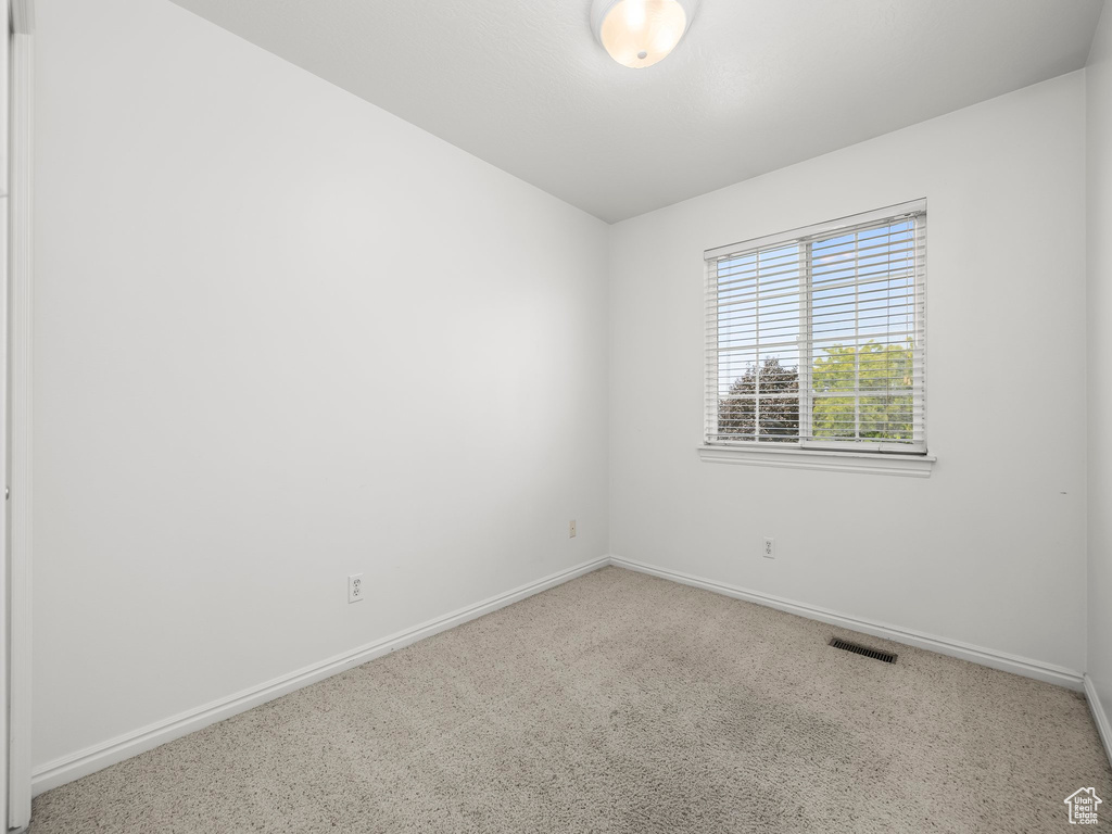 Carpeted empty room with baseboards
