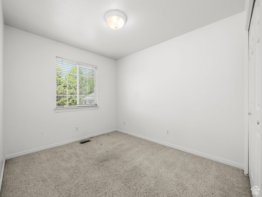 Empty room featuring baseboards and carpet