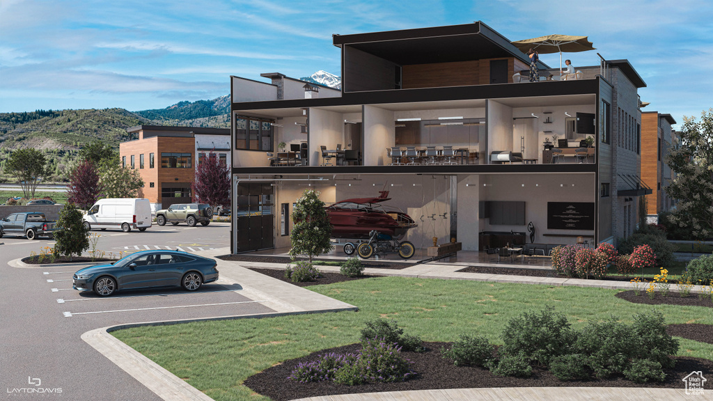 View of front of property featuring a mountain view, stucco siding, and a front lawn