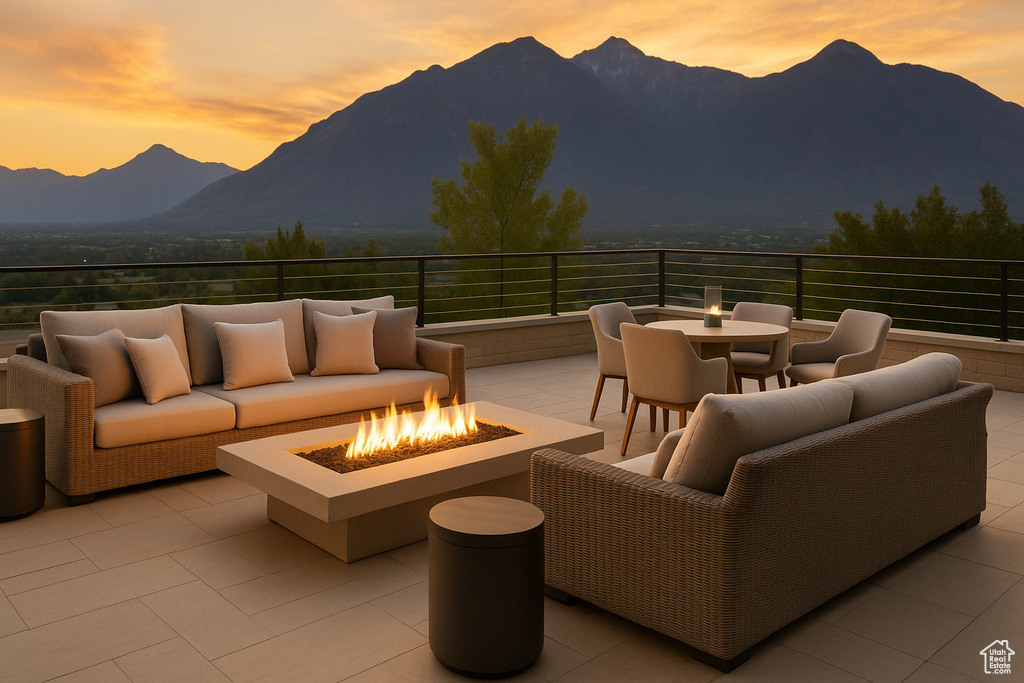 Patio terrace at dusk featuring a mountain view, an outdoor living space with a fire pit, a patio area, and outdoor dining space