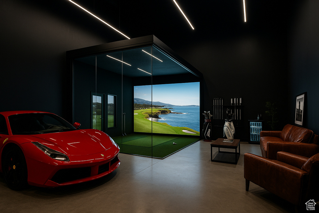Playroom with finished concrete floors, golf simulator, a water and mountain view, and a towering ceiling