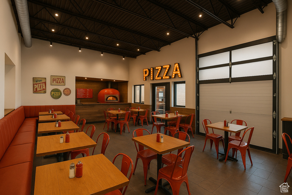 Recreation room with a towering ceiling, wooden walls, track lighting, and a wainscoted wall