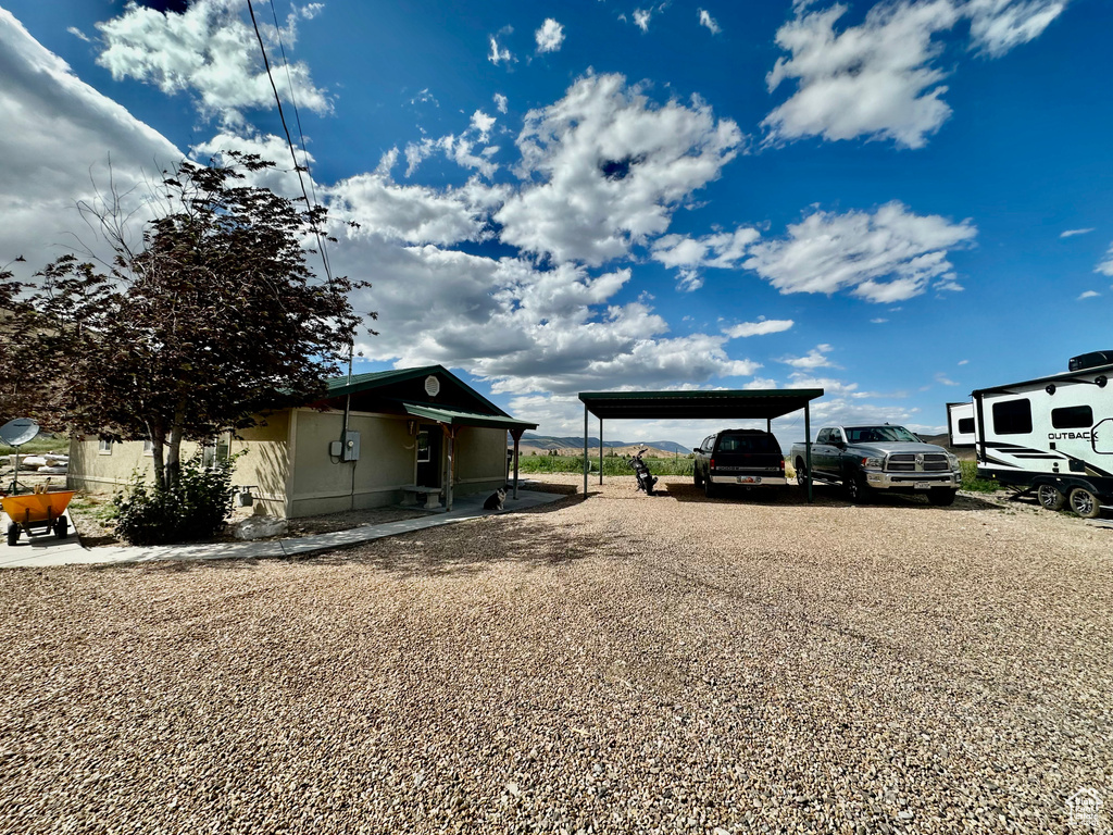 View of yard featuring a detached carport and gravel driveway