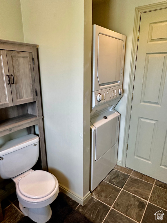 Half bath with toilet and stacked washer / dryer