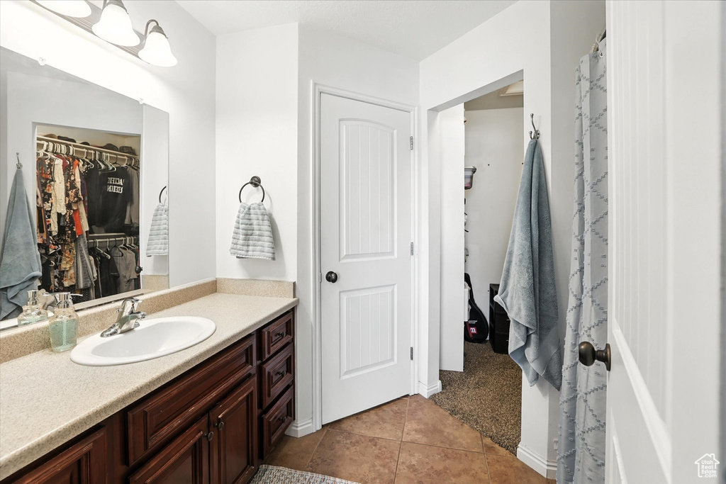 Bathroom featuring vanity, tile patterned flooring, and a walk in closet