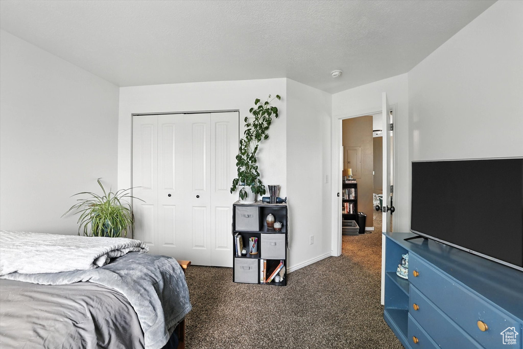 Bedroom featuring dark carpet and a closet