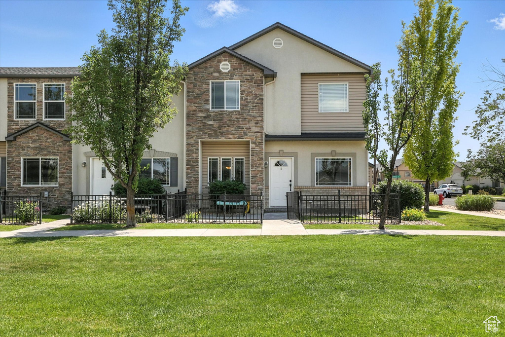 View of property with stone siding, stucco siding, and a fenced front yard