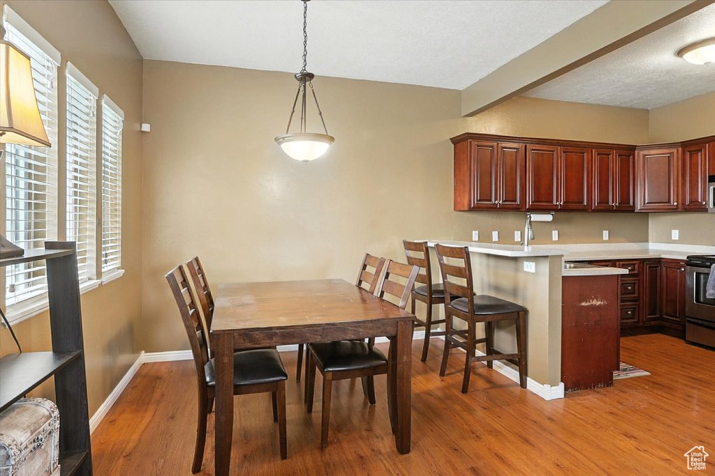 Dining space with light wood-type flooring and baseboards