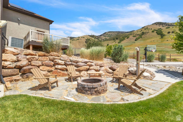 View of patio / terrace with an outdoor fire pit and a deck with mountain view