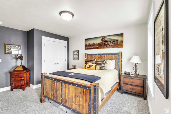 Bedroom with light colored carpet and a closet