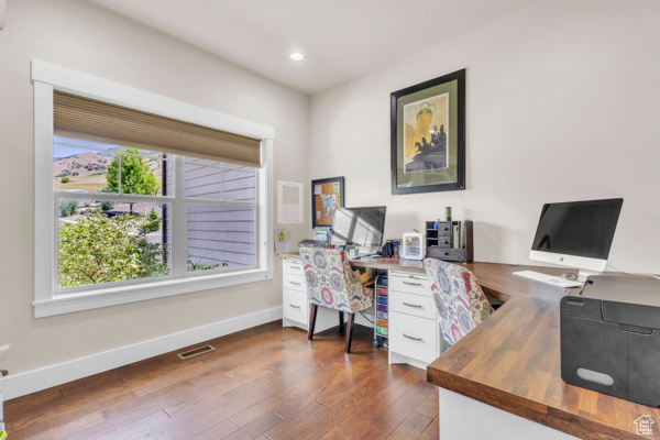 Office area with dark wood finished floors and recessed lighting