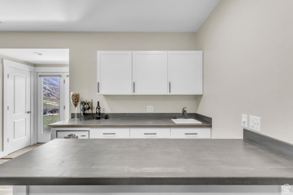 Kitchen featuring white cabinets and stainless steel counters