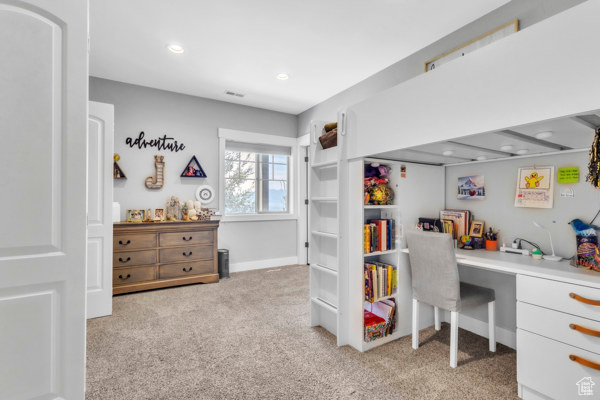 Home office with light carpet, built in desk, and recessed lighting