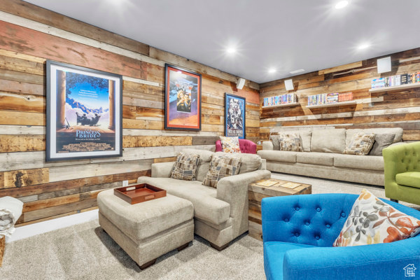 Carpeted living room featuring wood walls and recessed lighting