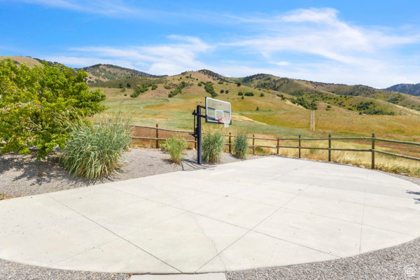View of patio / terrace featuring basketball court, a mountain view, and a view of rural / pastoral area