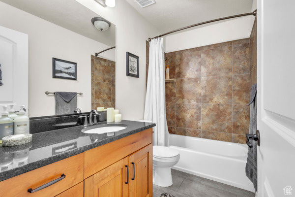 Full bathroom featuring vanity, shower / tub combo, and tile patterned flooring
