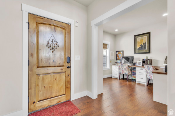 Foyer entrance with dark wood finished floors and recessed lighting