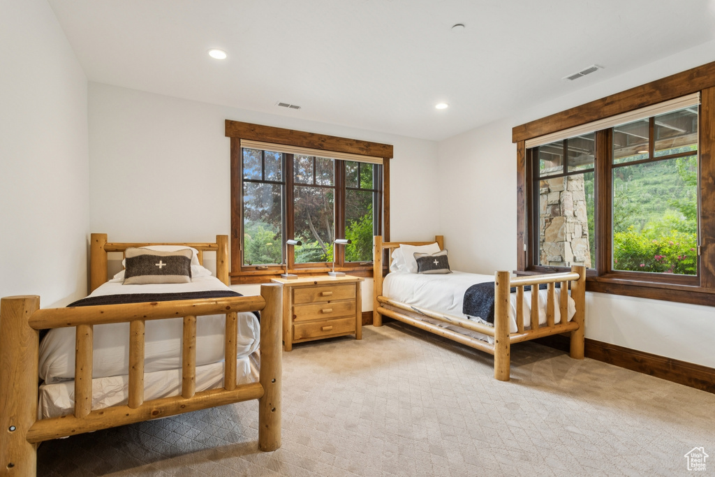 Bedroom with light colored carpet and recessed lighting