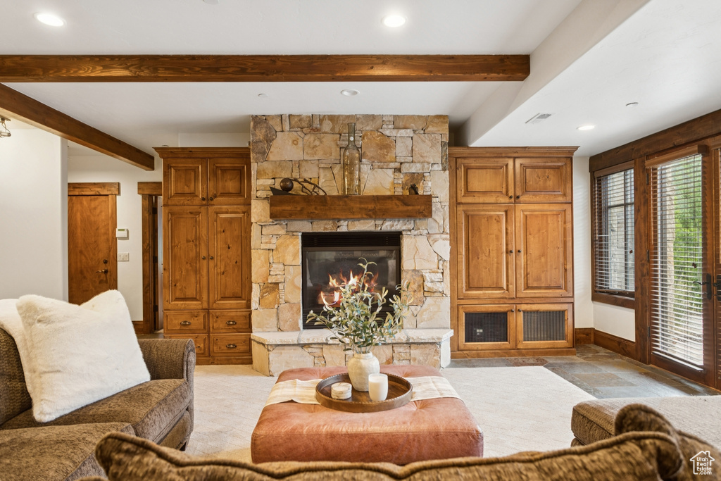 Living room featuring beamed ceiling, a fireplace, and recessed lighting